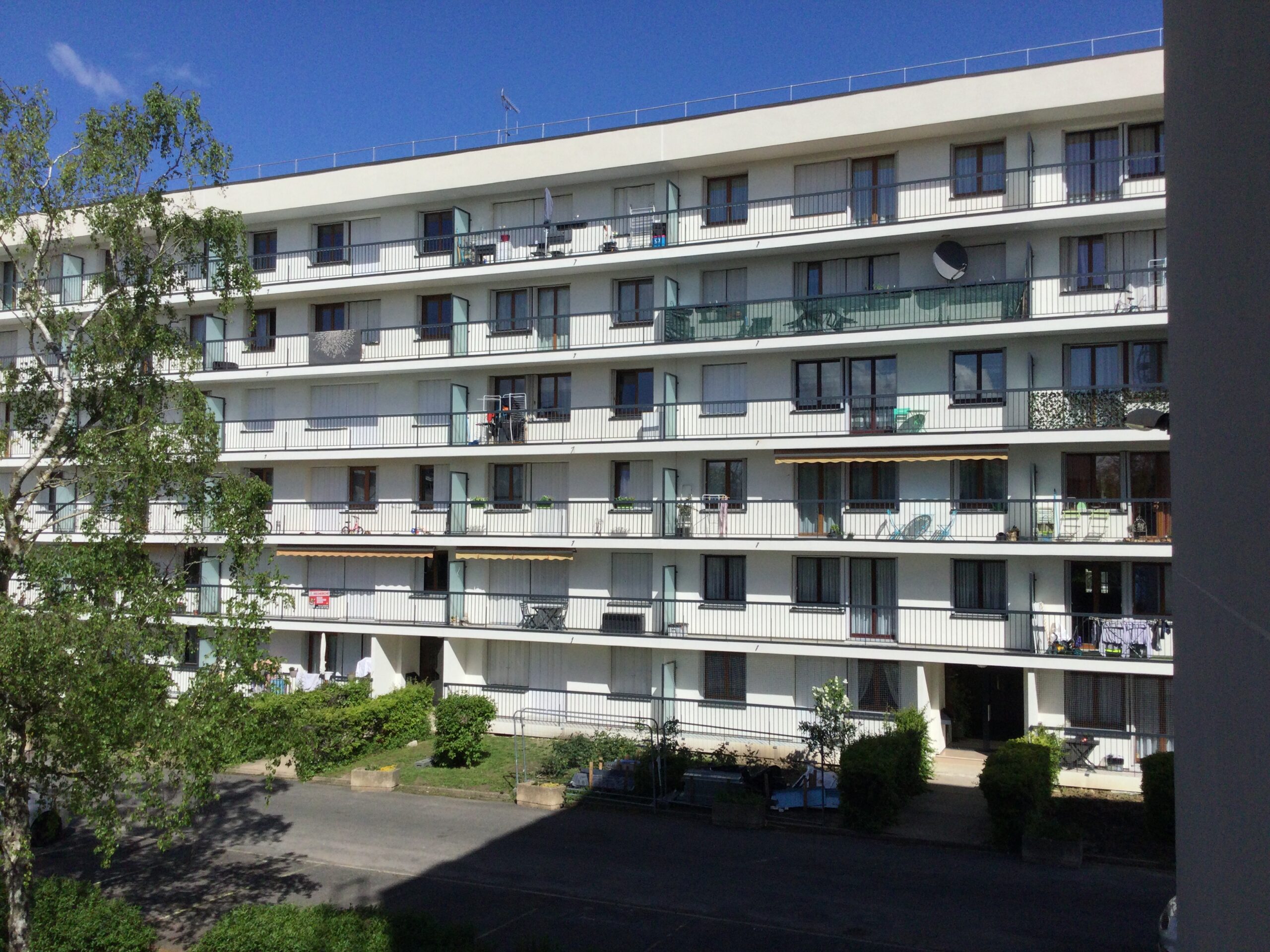 La Dauphine Façades rénovées de la copropriété Les Vingt Arpents à Crosne, entourée d'espaces verts